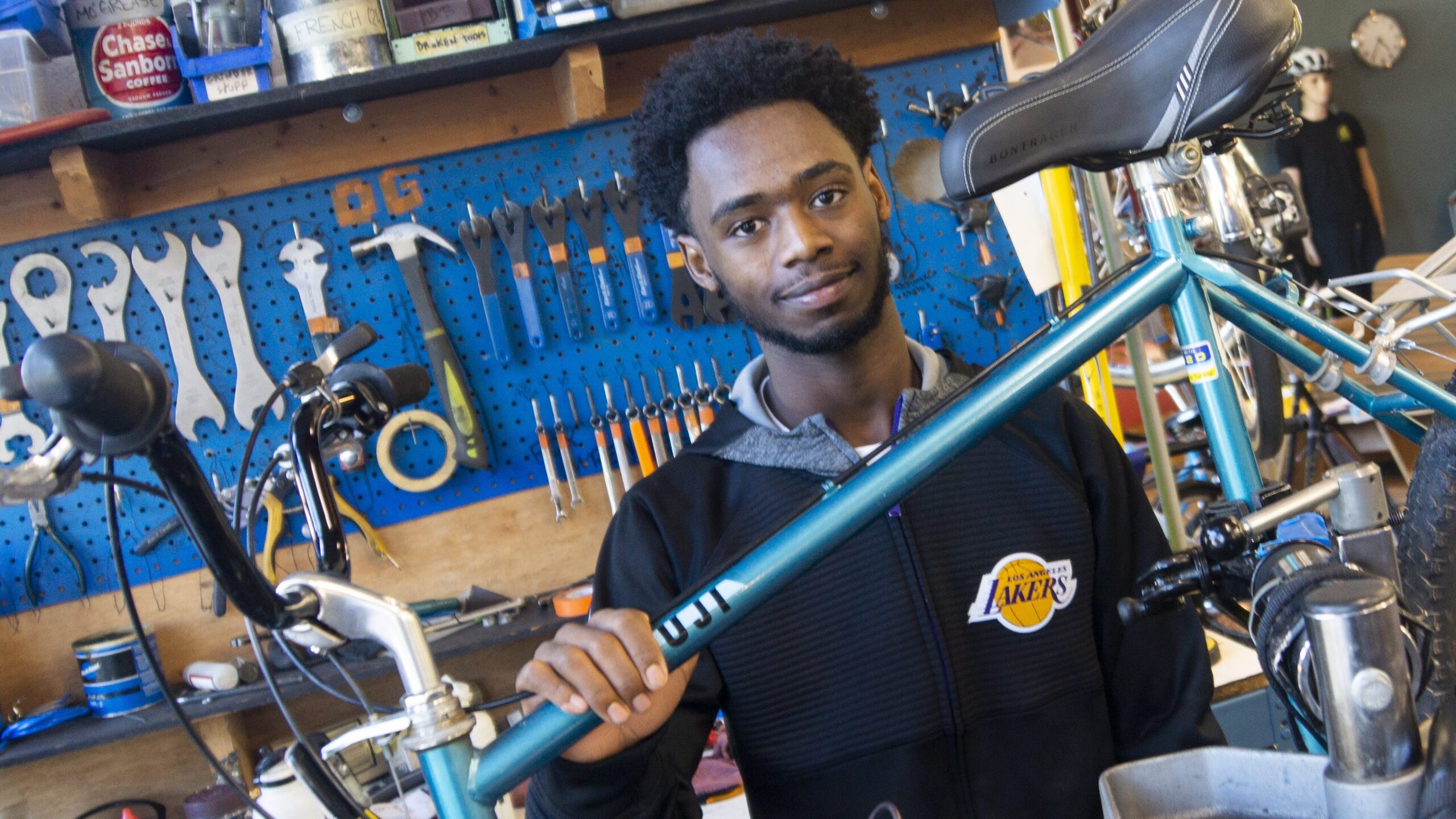 Bike mechanic holds bike frame in bike shop