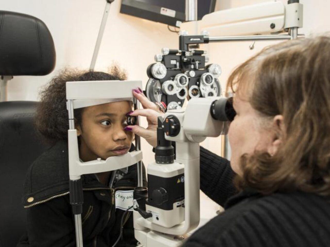 An African American girl gets an eye exam