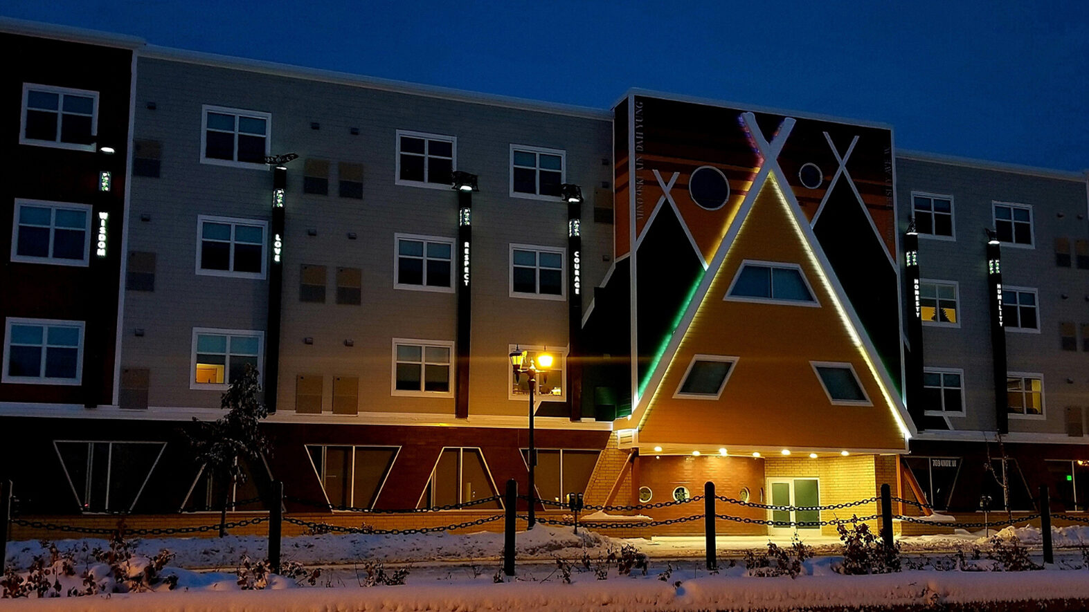 Exterior of Mino Oski Ain Dah Yung supportive housing complex for young adults, showing lighted entryway