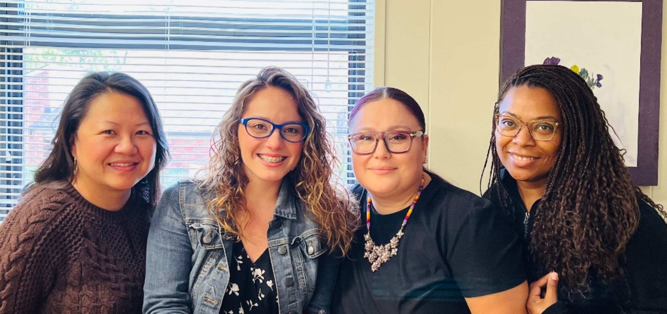 Four smiling people standing together