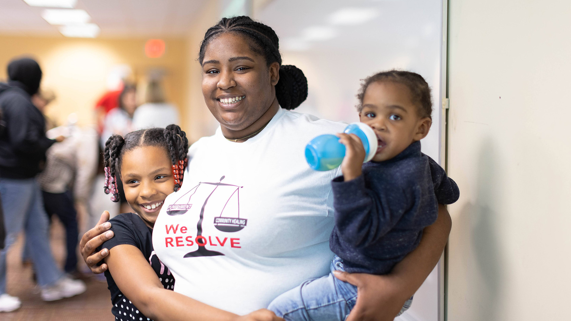 Smiling woman with 2 young children at an event